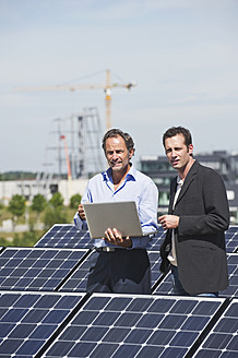 Deutschland, München, Ingenieur und Mann diskutieren in Solaranlage - WESTF017900