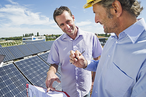 Deutschland, München, Mann diskutiert mit Ingenieur in Solaranlage - WESTF017904