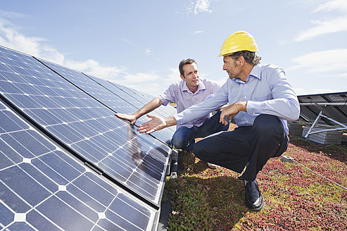 Deutschland, München, Mann diskutiert mit Ingenieur in Solaranlage - WESTF017905