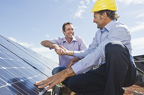 Deutschland, München, Mann schüttelt lächelnd einem Ingenieur in einer Solaranlage die Hand - WESTF017906