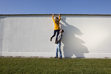 Germany, Bavaria, Munich, Young couple climbing wall - RBF000729