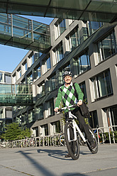 Germany, Bavaria, Mature man on bicycle, smiling, portrait - RNF000672