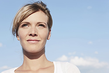 A cheerful young woman in Cologne, Germany, gazes off into the distance with a bright smile on her face - WESTF017918