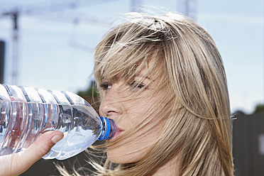 Junge Frau in Köln trinkt frisches Trinkwasser aus der Leitung - eine gesunde und umweltfreundliche Wahl - WESTF017958