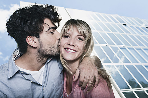 Romantisches Pärchen in Köln - Junger Mann zeigt seine Liebe mit einem Kuss und die Frau lächelt glücklich zurück - WESTF017989