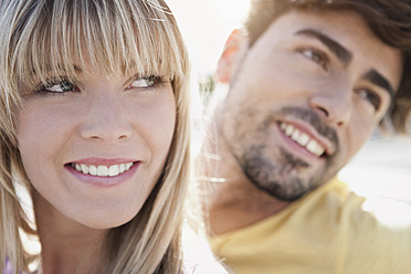 A happy young couple in Cologne, Germany, captured in a close-up shot with beaming smiles - WESTF018003