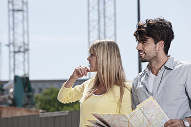 Adventurous couple navigates the streets of Cologne with the help of a trusty map in hand - WESTF018015