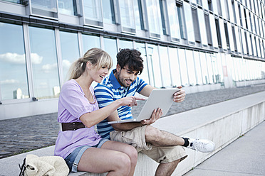 Glückliches Paar in Köln arbeitet gemeinsam am Laptop und strahlt vor Freude - WESTF018022