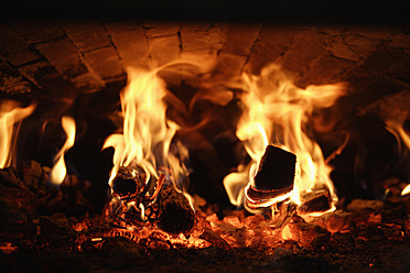 Close-up of a wood stove bakery in Egling, Upper Bavaria, Germany, with flames flickering inside - TCF001922