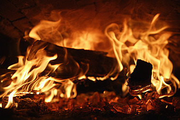 Close-up of a fire in the wood stove bakery in Egling, Upper Bavaria, Germany - TCF001923
