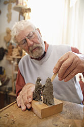 Craftsman carving a statue in Upper Bavaria, Germany - TCF001974