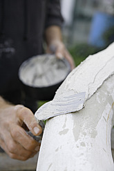 A sculptor in Schaeftlarn, Upper Bavaria, Munich, applies plaster with a trowel to create their masterpiece - TCF001983