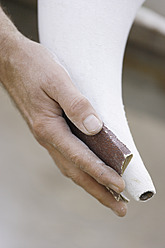 A sculptor in Schaeftlarn, Upper Bavaria, Munich, carefully polishes a plaster creation - TCF001993