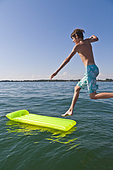 Ein kleiner Junge springt freudig in das erfrischende Wasser des Bodensees in Baden-Württemberg, Deutschland - WDF001096