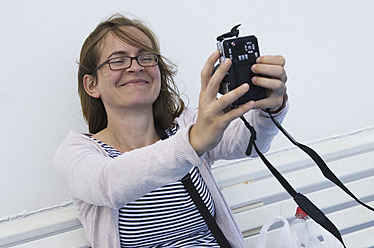 Erinnerungen auf der schönen Insel Ithaka, Griechenland, festhalten - eine Frau im mittleren Erwachsenenalter lächelt für ein Selfie - MUF001130