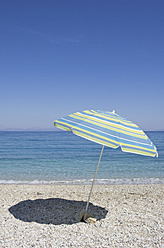 Enjoy a serene beach day on Ithaca, one of Greece's stunning Ionian Islands, under a colorful sunshade - MUF001145