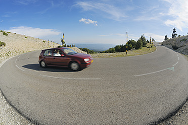 Ein Auto fährt auf einer kurvenreichen Straße in der malerischen Region Vaucluse in Südfrankreich - RUEF000736