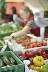 Auf dem lebhaften Markt von Wolfratshausen, Oberbayern, Deutschland, wählt eine Frau ihre Produkte mit großer Sorgfalt aus - TCF002110