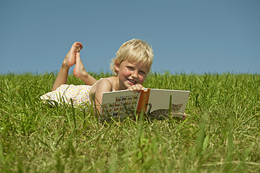 Ein friedlicher Moment in Bayern, als ein junges Mädchen sich in ein Buch vertieft, umgeben von der stillen Schönheit der Natur - RNF000749