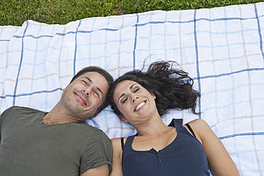 A couple basks in the Bavarian sun, lounging on a comfortable picnic blanket amidst lush greenery - SKF000585