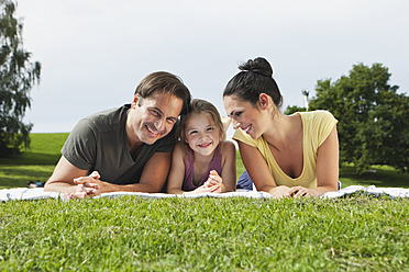 A joyful Bavarian family basks in the sun, lounging on a comfortable blanket and beaming with happiness - SKF000603