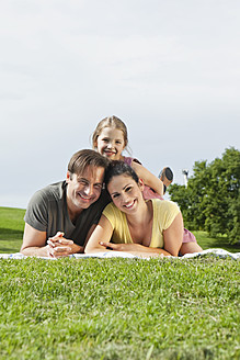 Eine fröhliche bayerische Familie, die sich in der Sonne sonnt, sich auf einer Picknickmatte ausruht und für einen Schnappschuss strahlt - SKF000604