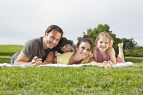 Eine fröhliche bayerische Familie, die sich in der Sonne sonnt, sich auf einer Picknickmatte ausruht und für einen Schnappschuss strahlt - SKF000607