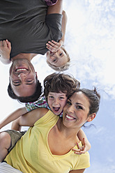 Eine bayerische Familie verbringt einen vergnüglichen Tag im Park, die Eltern tragen ihre Kinder und alle posieren fröhlich - SKF000610
