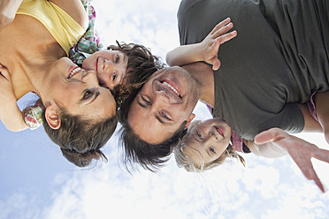 A family enjoys a Bavarian park as parents carry their children on their backs, all smiling with joy - SKF000612
