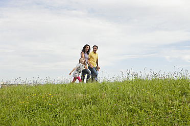 A Bavarian family enjoying a leisurely walk in a picturesque German park, surrounded by lush greenery - SKF000616