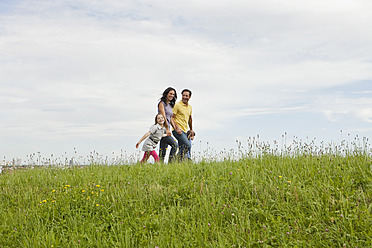 Eine bayerische Familie genießt einen gemütlichen Spaziergang in einem malerischen deutschen Park, umgeben von üppiger Vegetation - SKF000616