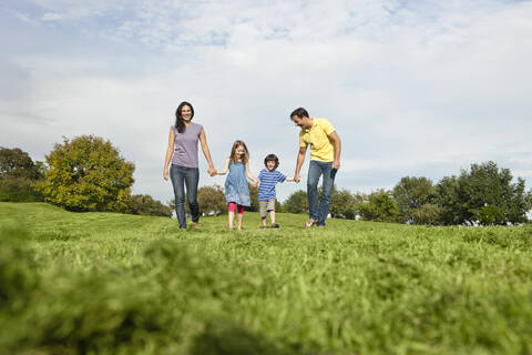 Germany, Bavaria, Family walking in grass at park stock photo