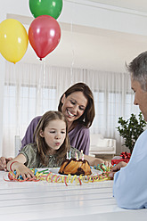 Glückliche Familie in München, die mit einem breiten Lächeln auf dem Gesicht einen Geburtstag in Deutschland feiert - SKF000670