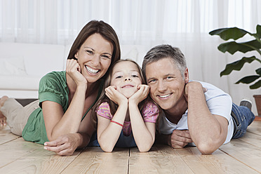 Eine glückliche Familie genießt die gemeinsame Zeit in München, Deutschland, festgehalten in einem fröhlichen Porträt auf dem Boden - SKF000678