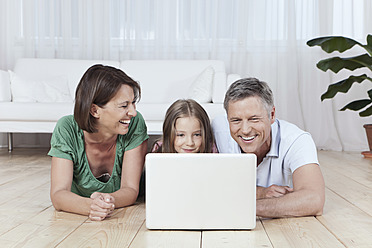 A happy family in Munich, Germany, enjoying quality time together while using their laptop - SKF000681