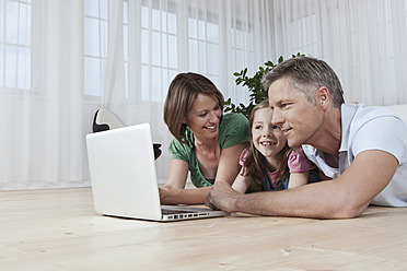 A happy family in Munich, Germany, enjoying quality time together while using their laptop - SKF000682