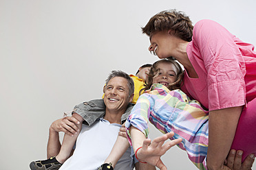 Happy parents in Munich, Germany, joyfully carry their children while beaming with smiles - SKF000689