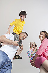 Happy parents in Munich, Germany, joyfully carry their children while smiling - SKF000691
