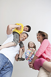 Glückliche Familien in München, Deutschland: Eltern tragen ihre Kinder mit Freude und lächeln gemeinsam - SKF000692