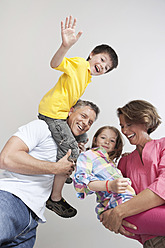 Glückliche Familien in München, Deutschland: Eltern tragen ihre Kinder mit einem Lächeln auf den Schultern - SKF000693