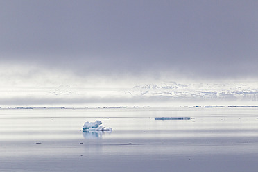 Blick auf einen kleinen Eisberg, der auf dem kristallklaren Wasser von Spitzbergen, Svalbard in Norwegen, Europa, treibt - FOF003734