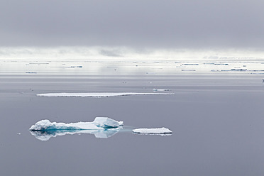 Blick auf einen kleinen Eisberg, der auf dem kristallklaren Wasser von Spitzbergen, Svalbard in Norwegen, Europa, treibt - FOF003735