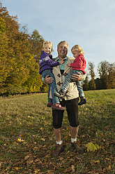 Ein glücklicher Familienmoment im bayerischen Herbst: Der Großvater genießt die Zeit mit seinen Enkelinnen, die alle lächeln - RNF000795