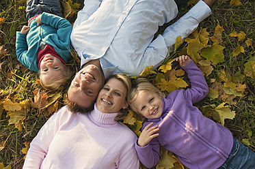 Eine fröhliche bayerische Familie, die die Schönheit des Herbstlaubs genießt, festgehalten in einem gemütlichen und einladenden Porträt - RNF000835