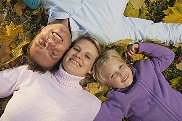 Eine fröhliche bayerische Familie genießt die herbstliche Schönheit, sonnt sich in den leuchtenden Blättern und strahlt über das ganze Gesicht - RNF000836