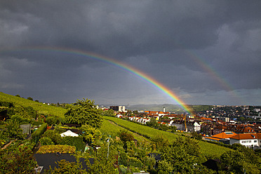 Deutschland, Würzburg, Blick auf die Stadt mit Gewitterwolken und Regenbogen - NDF000211