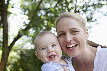 Germany, Bavaria, Munich, Mother and baby boy in garden, smiling - RBF000783