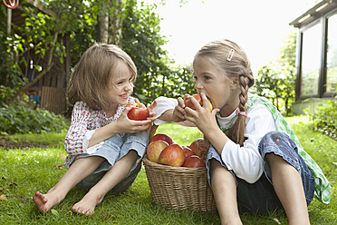 Deutschland, Bayern, München, Mädchen essen Apfel im Garten - RBF000787