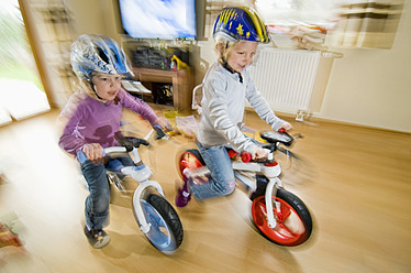 Deutschland, Bayern, Mädchen spielen mit Fahrrad im Wohnzimmer - RNF000837