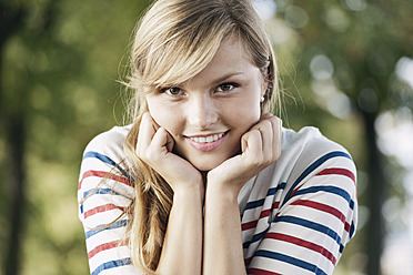 Germany, Cologne, Young woman smiling, portrait - FMKF000372